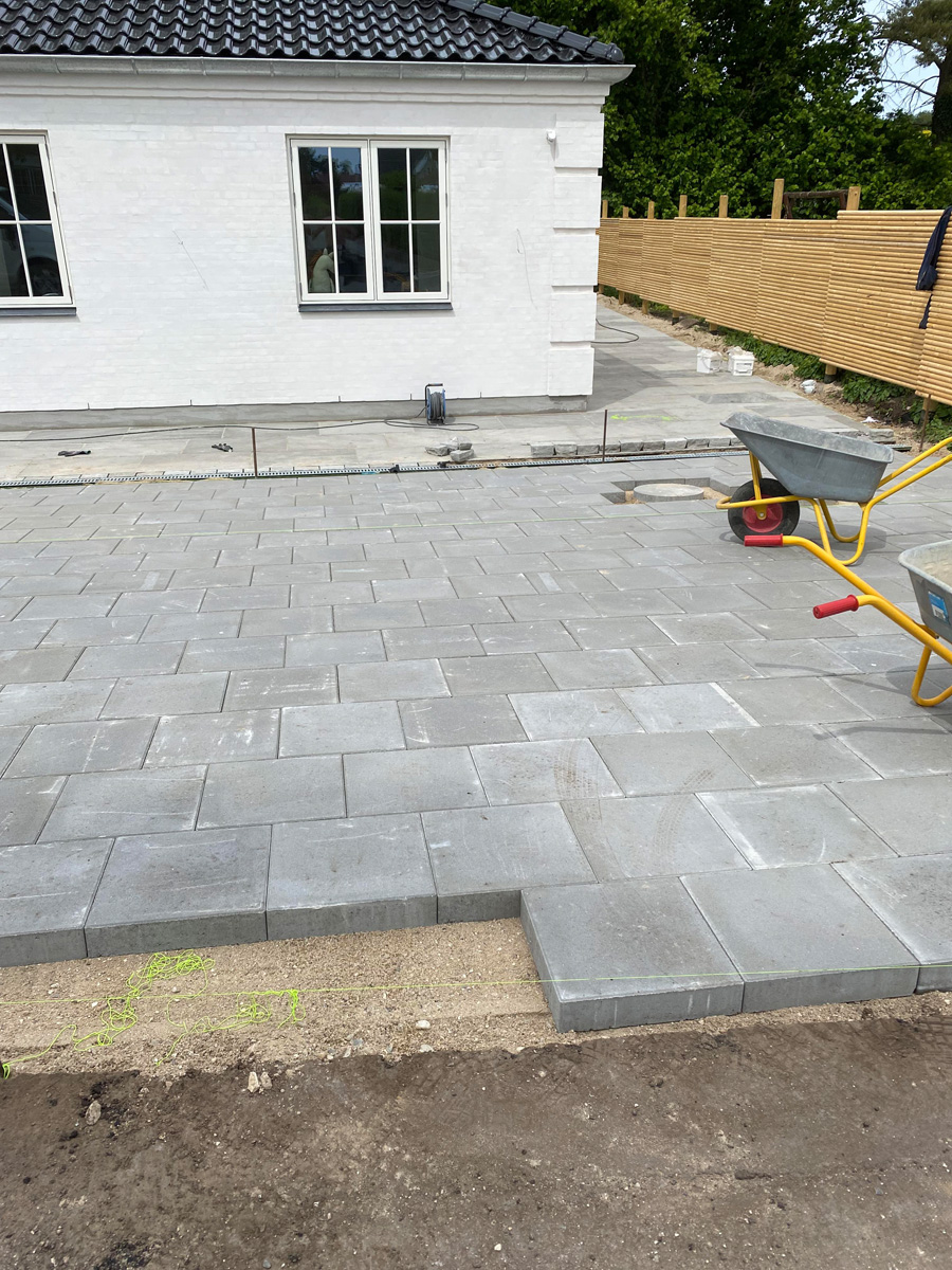 Stor terrasse med betonbelægning ved nyt byggeri i Allerød af Haarkjær Byg
